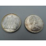 A French silver 10 Franc coin and a Canadian coin