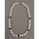 A pearl necklace with diamond set enamel spacers. 45 cm long.