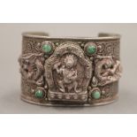 An unmarked Tibetan silver and turquoise bangle. 7 cm wide.