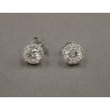 A pair of 18 ct gold diamond stud earrings, each central stone spreading to approximately 1 carat.