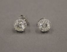 A pair of 18 ct gold diamond stud earrings, each central stone spreading to approximately 1 carat.