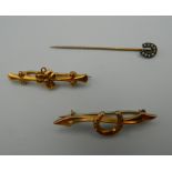 Two 9 ct gold brooches, the largest 3.5 cm long, 1.9 grammes total weight; and a horseshoe stickpin.