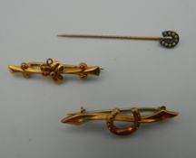 Two 9 ct gold brooches, the largest 3.5 cm long, 1.9 grammes total weight; and a horseshoe stickpin.