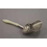 A silver and mother-of-pearl caddy spoon. 7 cm long.