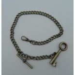 A key shaped cigar cutter on Albert chain. The chain 35 cm long.
