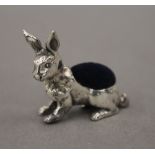 A silver pin cushion in the form of a rabbit. 3 cm long.