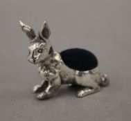 A silver pin cushion in the form of a rabbit. 3 cm long.