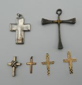 A quantity of cross formed pendants. The largest 6 cm high.