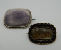 A 19th century unmarked gold mourning brooch and an amethyst set silver brooch.