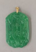 A gold topped apple green jade pendant. 6 cm high.