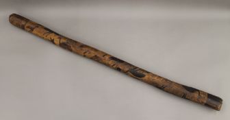 A carved Aboriginal didgeridoo. 100 cm long.