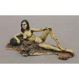 A cold painted bronze model of a nude lady on a tiger skin rug. 15 cm wide.