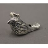 A silver whistle formed as a bird. 3 cm long.