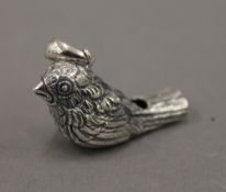 A silver whistle formed as a bird. 3 cm long.