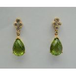 A pair of 18 ct gold peridot and diamond drop earrings. Each 2.5 cm high.
