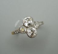 An 18 ct gold diamond cluster ring, the two central stones spreading to approximately 0.