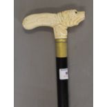 A walking stick with a carved bone dog formed handle. 89.5 cm high.