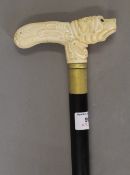 A walking stick with a carved bone dog formed handle. 89.5 cm high.