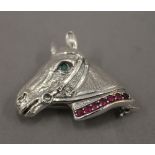 A silver horse head brooch/pendant. 3 cm wide.