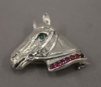 A silver horse head brooch/pendant. 3 cm wide.