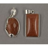 Two silver goldstone pendants. The largest 3 cm high.