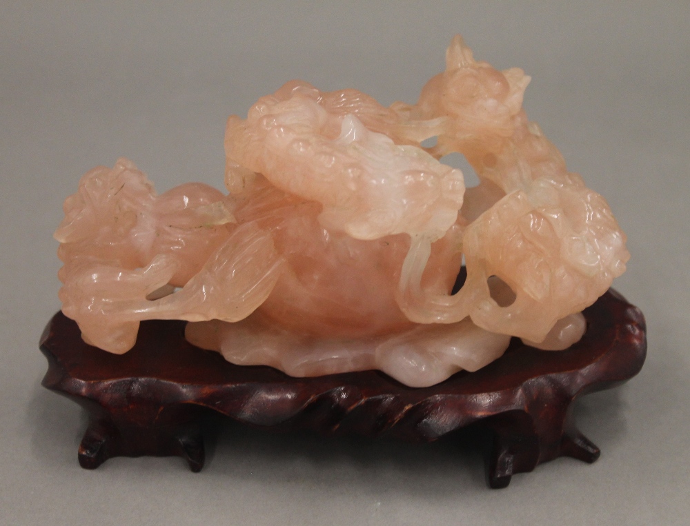 A Chinese carved rose quartz group formed as dogs-of-fo, on a carved wooden stand. - Image 5 of 5