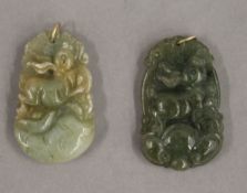 Two jade pendants, each with gold suspension loops. Each 3.5 cm high.