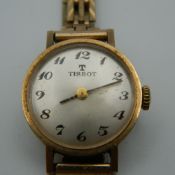 A 9 ct gold Tissot ladies wristwatch. 2 cm wide. 16 grammes total weight.