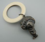 A silver rattle formed as a golly. 5.5 cm high.