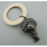 A silver rattle formed as a golly. 5.5 cm high.