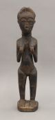 A carved wooden tribal figure of a female. 23 cm high.