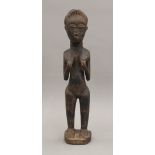 A carved wooden tribal figure of a female. 23 cm high.