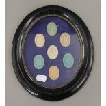 Seven seals, housed in a black oval frame. 25 cm high.