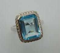A 9 ct white gold Art Deco style diamond and blue topaz ring. Ring size M.