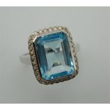 A 9 ct white gold Art Deco style diamond and blue topaz ring. Ring size M.