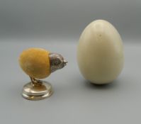 A silver chick form pin cushion, housed in a lined egg shaped box. The pin cushion 4.5 cm high.