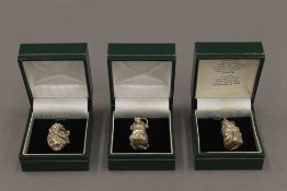 Three silver fob charms. Each approximately 2.5 cm high.