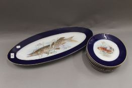 A set of porcelain plates decorated with fish. The largest 60 cm wide.
