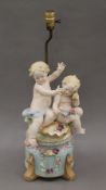 A Continental bisque porcelain table lamp formed as cherubs. 58 cm high overall.