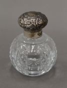 A silver topped cut glass scent bottle. 9 cm high.