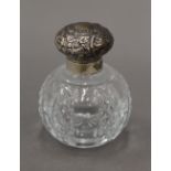 A silver topped cut glass scent bottle. 9 cm high.