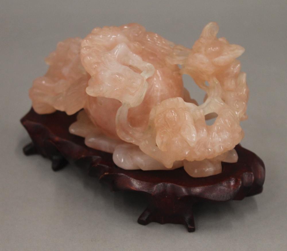 A Chinese carved rose quartz group formed as dogs-of-fo, on a carved wooden stand. - Image 4 of 5