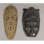 Two African carved wooden masks. The largest 45 cm high.