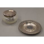 A silver coin set dish and a silver topped jar. The former 11.5 cm diameter. 3.3 troy ounces.