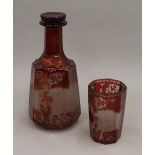A 19th century Bohemian engraved ruby glass decanter and glass. The former 23 cm high.