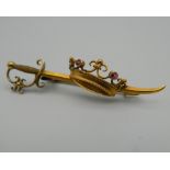 A 15 ct gold bar brooch formed as a sword and a coronate. 4.5 cm wide. 3.3 grammes total weight.