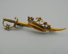 A 15 ct gold bar brooch formed as a sword and a coronate. 4.5 cm wide. 3.3 grammes total weight.