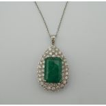 An 18 ct white gold diamond and emerald pendant on chain. The pendant 3.5 cm high. 15.