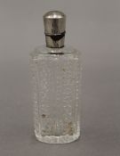 A silver topped cut glass perfume/scent bottle. 8.5 cm high.