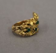 A Contemporary 18 ct gold emerald set ring. Ring size F/G. 11.8 grammes total weight.